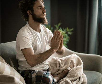 A Strong Man in Pajamas Has his Meditation. Usual Meditation at the Beginning of the Day. Close-up. High quality photo