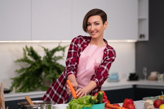 Washing and preparing ingredients on table young woman cooking a lunch standing in the kitchen. Healthy food living. Healthy lifestyle. Cooking at home for loving family.