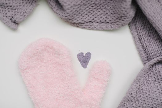 Minimal flat lay composition of massage mitten washcloth and a heart made of violet powder on a white background. Concept of zero waste.