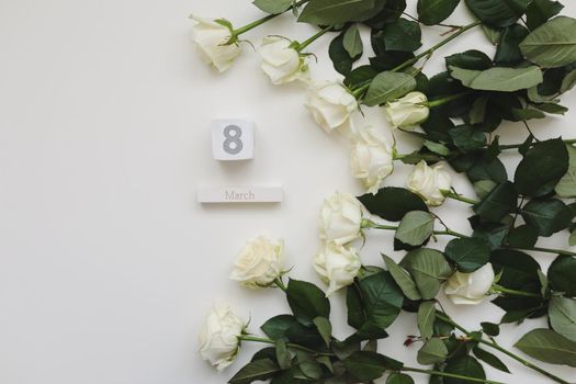 8 March, Woman Day background with white roses and place for text on white background top view.