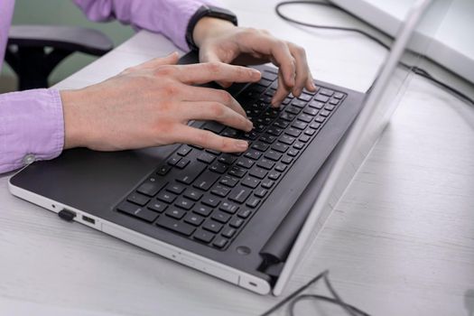 Man working at home office hand on keyboard close up.