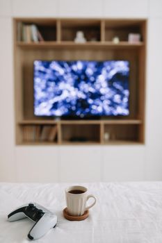 Game controller, joystick on TV screen background. Playing game console, weekend at home, leisure lifestyle concept. 