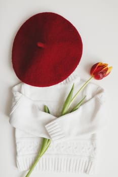 Overhead view of women clothes and bouquet of fresh tulips.