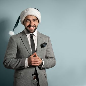 Christmas, business Concept. Handsome Business man celebrate merry Christmas and Santa hat. Bearded hipster wear formal suit and Santa hat smiles on isolated background. High quality photo