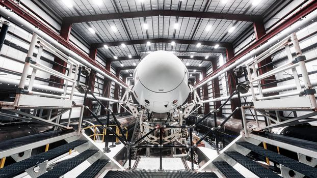 Space launch preparation. Spaceship atop the rocket, inside the hangar, just before rollout to the launchpad. Elements of this image furnished by NASA.