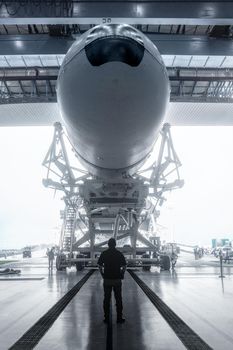 Space engineer looks at a built spacecraft. Rocket with spacecraft, rolls out of the hangar. Space launch preparation. rocket, inside the maintenance hangar. Elements of this image furnished by NASA.