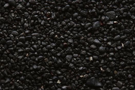 Texture of black volcanic sand for background. Black Sand beach macro photography. Close-up view of volcanic sand surface. Icelandic Black Sand macro photography. Black pebble background.