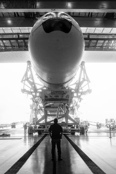 Space engineer looks at a built spacecraft. Rocket with spacecraft, rolls out of the hangar. Space launch preparation. rocket, inside the maintenance hangar. Elements of this image furnished by NASA.