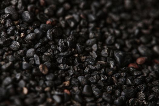 Texture of black volcanic sand for background. Black Sand beach macro photography. Close-up view of volcanic sand surface. Icelandic Black Sand macro photography. Black pebble background.