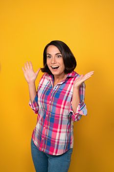 Beautiful girl with hands lifted up looking shocked and surprised smile on camera. Human emotions, facial expression concept.