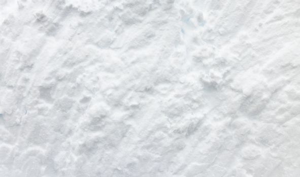 Wall of snow. Snowdrift surface, Winter background. The texture of snow removed with a bucket. Removed compressed snow.