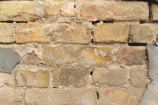 Texture of outer brick wall with old fallen cladding. Old building with falling off plaster. Background of brick wall pattern.