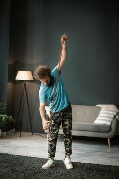 Active Man Takes His Rope to Jump on It. Fit guy wants to start his morning fitness in his living room. Full-length. High quality photo