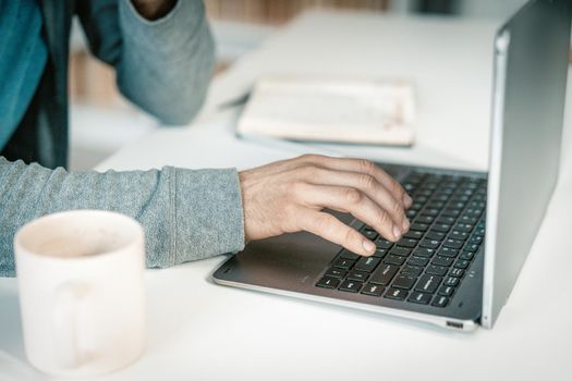 Office Worker Typing on the Laptop Keyboard in his office, Man Working on Laptop. Close-up of Hands on Laptop. High quality photo