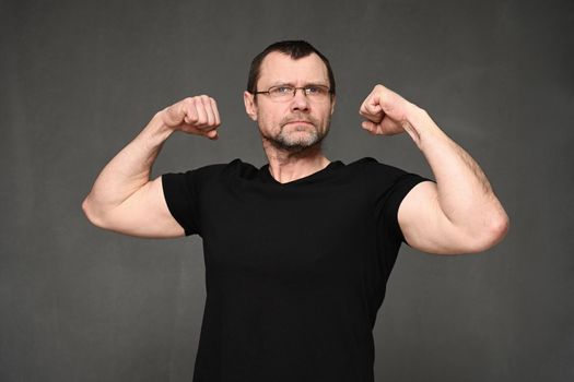 portrait of a cheerful man with glasses shows strength