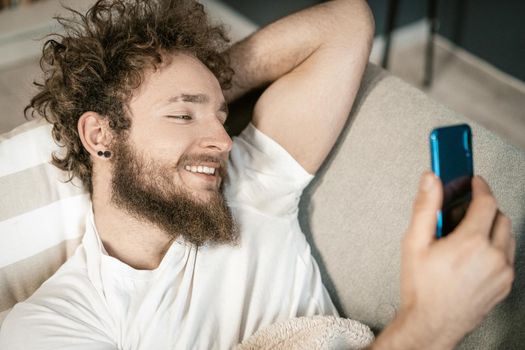 Man Looks Through Tabs on his Smartphone. He Reads New Posts in Social Networks. Selective Focus of Hands and Mobile Phone . High quality photo