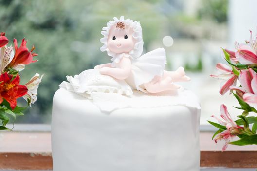 Cake for christening girl. Decorated with a doll and flowers