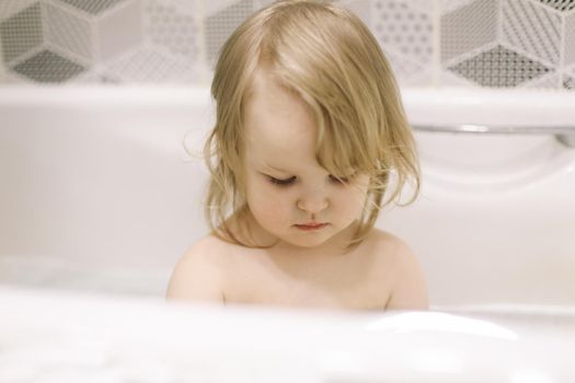 Child bathing. Little baby taking bath, closeup face portrait of smiling girl, health care and kids hygiene. 