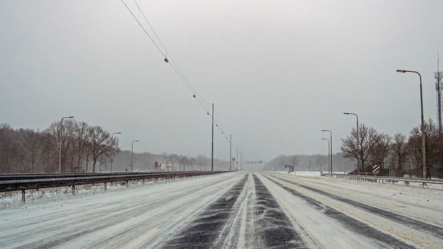 Driving in a snowstorm on the highway A1 near Amsterdam in the Netherlands in winter