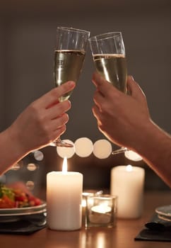 Cropped shot of a couple toasting during a romantic dinner.