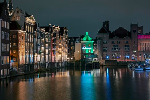 City scenic from Amsterdam at the Damrak in the Netherlands at night 