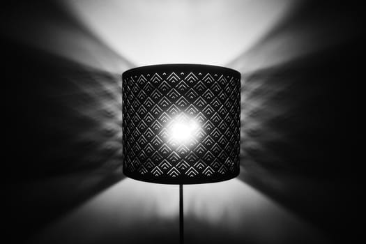 Floor lamp light. Rays of light through the holes in the lamp floor lamp. Bright shining lamp in the night.