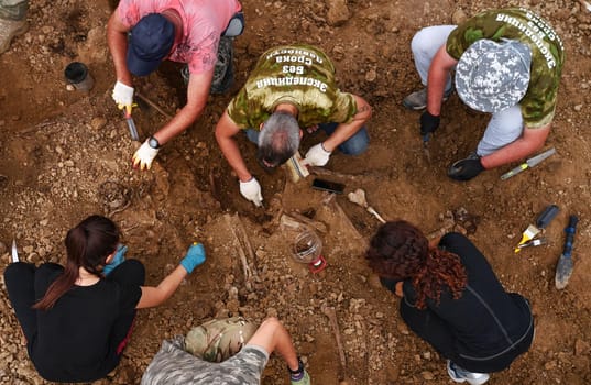 Excavations at the site of a war crime. Site of a mass shooting of people. Human remains (bones of skeleton, skulls). Human remains of victims of the Nazis. 28.08.2021, Rostov region, Russia.