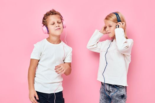 Stylish little boy and cute girl dancing with headphones entertainment studio childhood. High quality photo