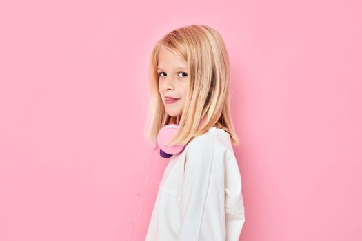 cute girl blonde hair headphones posing pink background. High quality photo