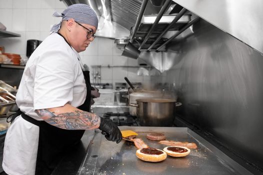 Burger Restaurant. Female Chef Cooking Burgers In Kitchen. High quality photo