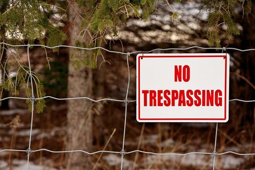 No Trespassing Sign Posted on a Wire Fence in a Rural Setting. High quality photo