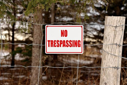 No Trespassing Sign Posted on a Wire Fence in a Rural Setting. High quality photo