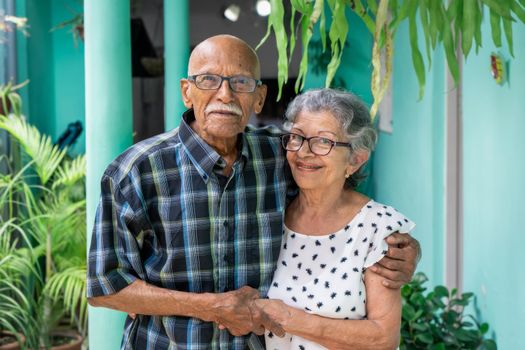 Elderly couple embracing and smiling looking at the camera