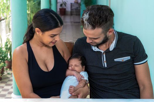 Photo of a baby in the arms of a woman and a man