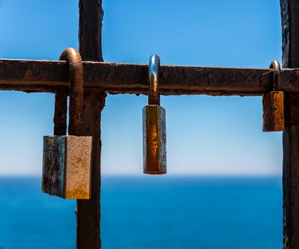 rusty padlock attached to a balustrade by the sea, a traditional way of showing love, relationship