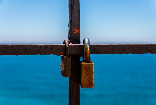 rusty padlock attached to a balustrade by the sea, a traditional way of showing love, relationship