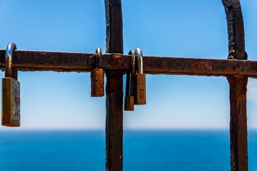 rusty padlock attached to a balustrade by the sea, a traditional way of showing love, relationship