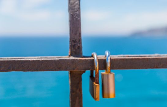 rusty padlock attached to a balustrade by the sea, a traditional way of showing love, relationship