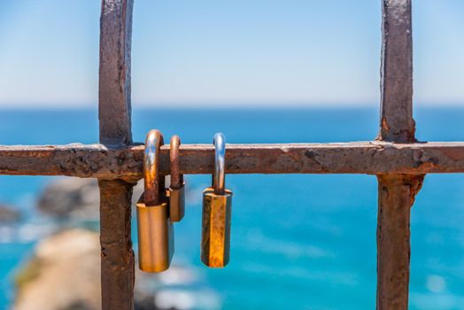 rusty padlock attached to a balustrade by the sea, a traditional way of showing love, relationship