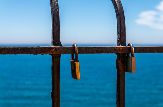 rusty padlock attached to a balustrade by the sea, a traditional way of showing love, relationship