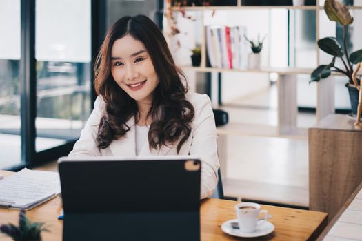 Asian business woman having video call with business team to consult about business plan of company. Online team meeting video conference