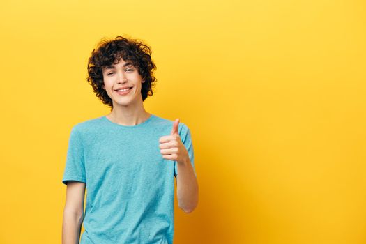 smiling guy showing thumb up yellow background. High quality photo