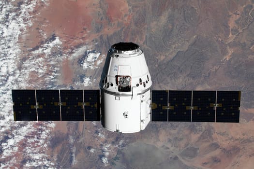 The SpaceX Dragon resupply ship is pictured approaching the International Space Station. Elements of this image furnished by NASA.