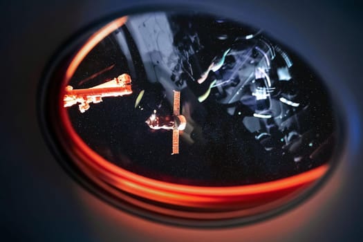 View on ISS Progress resupply ship, View out from a passenger window on the SpaceX Crew Dragon. Docking maneuver near the Space Station. Elements of image furnished by NASA.