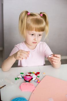 A blogger girl makes a felt craft for Valentine's Day in the shape of a heart. The concept of children's creativity and handmade.