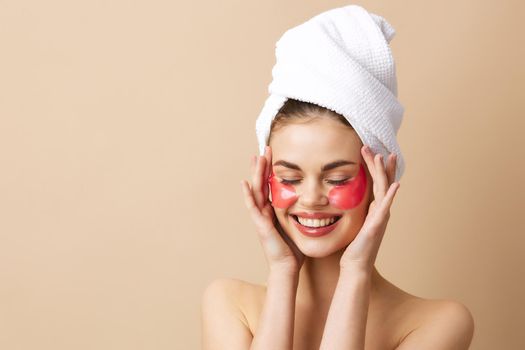 young woman pink patches on the face with a towel on the head close-up Lifestyle. High quality photo