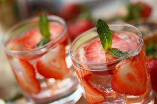 Close-up of strawberry punch homemade cooling drink in summer hot weather. Mint leaves in alcoholic beverages. Cocktail, smoothie, refresh, juice concept