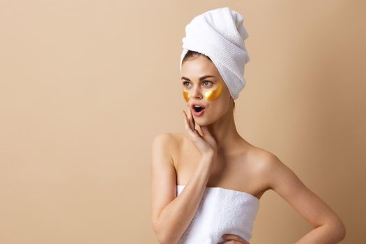 woman with a towel on his head gesturing with his hands skin care close-up Lifestyle. High quality photo
