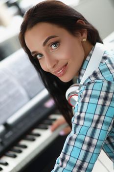 Portrait of female playing on white and black keyboards on piano, beautiful creative musician. Talented woman play new song. Hobby, perform, solo concept