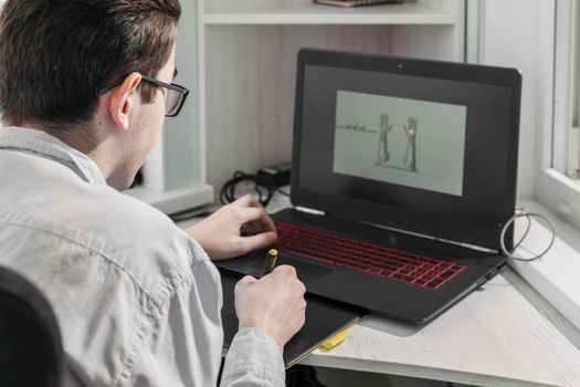 man creates video games. a designer creates a 3d model on his laptop